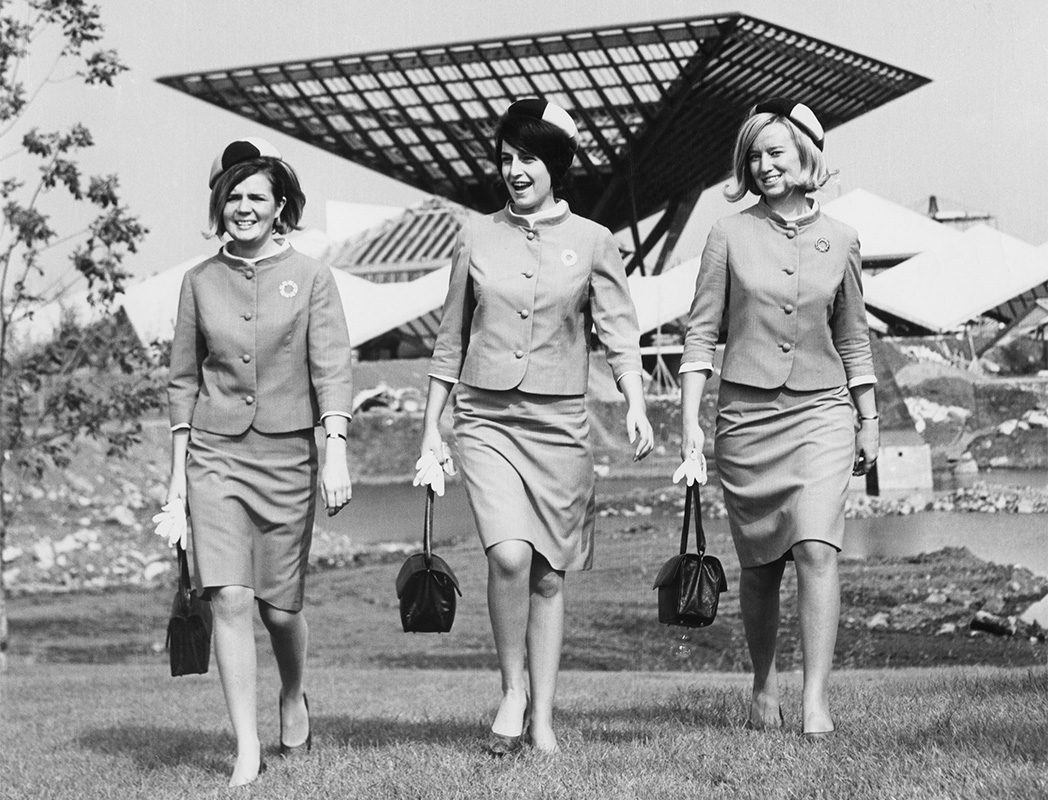 Trois hôtesses d’Expo 67, Danièle Touchette, Jean Murin et Lyse Michaud en face de la grande pyramide inversée « Katimavik » du pavillon du Canada, 1967. Courtoisie : Danièle Touchette