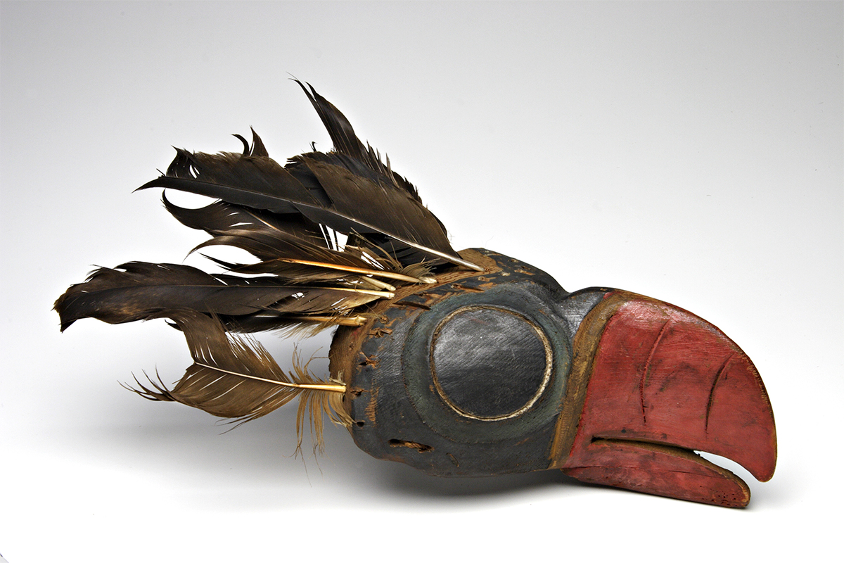 Puffin forehead mask. 1800-1850. Unknown artist. Red cedar wood, paint, eagle feathers?, fibre. Collected by George Mercer Dawson, possibly in Q’una (Skedans), 1878.  ME892.10 © McCord Museum.