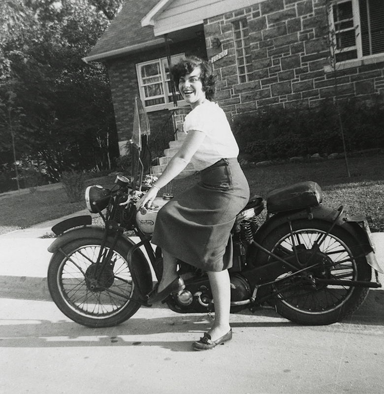 Photographe inconnu, <i>Shirley Sutcliffe sur une motocyclette, rue Saint-Urbain, Montréal</i>, 1951. Don de Peter, Paul, Robert et Carolyn Sutcliffe, M2011.64.2.6.261, Musée McCord